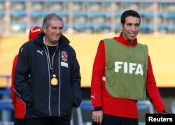 FILE - Head coach Manuel Jose de Jesus and Egypt's football star Mohamed Aboutrika take part in a practice session for the FIFA Club World Cup in Tokyo, Dec. 12, 2008.