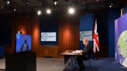 Britanski premijer Boris Johnson sluša američkog predsjednika Joea Bidena kako govori na globalnom samitu o klimi, iz sobe za brifinge u Downing Street, 22. aprila 2021.
