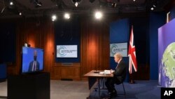 Britanski premijer Boris Johnson sluša američkog predsjednika Joea Bidena kako govori na globalnom samitu o klimi, iz sobe za brifinge u Downing Street, 22. aprila 2021.
