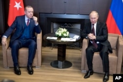 FILE - Russian President Vladimir Putin, right, talks with Turkish President Recep Tayyip Erdogan during their meeting in the Bocharov Ruchei residence in the Black Sea resort of Sochi, Russia, Nov. 13, 2017.
