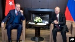 Russian President Vladimir Putin, right, talks with Turkish President Recep Tayyip Erdogan during their meeting in the Bocharov Ruchei residence in the Black Sea resort of Sochi, Russia, Nov. 13, 2017.