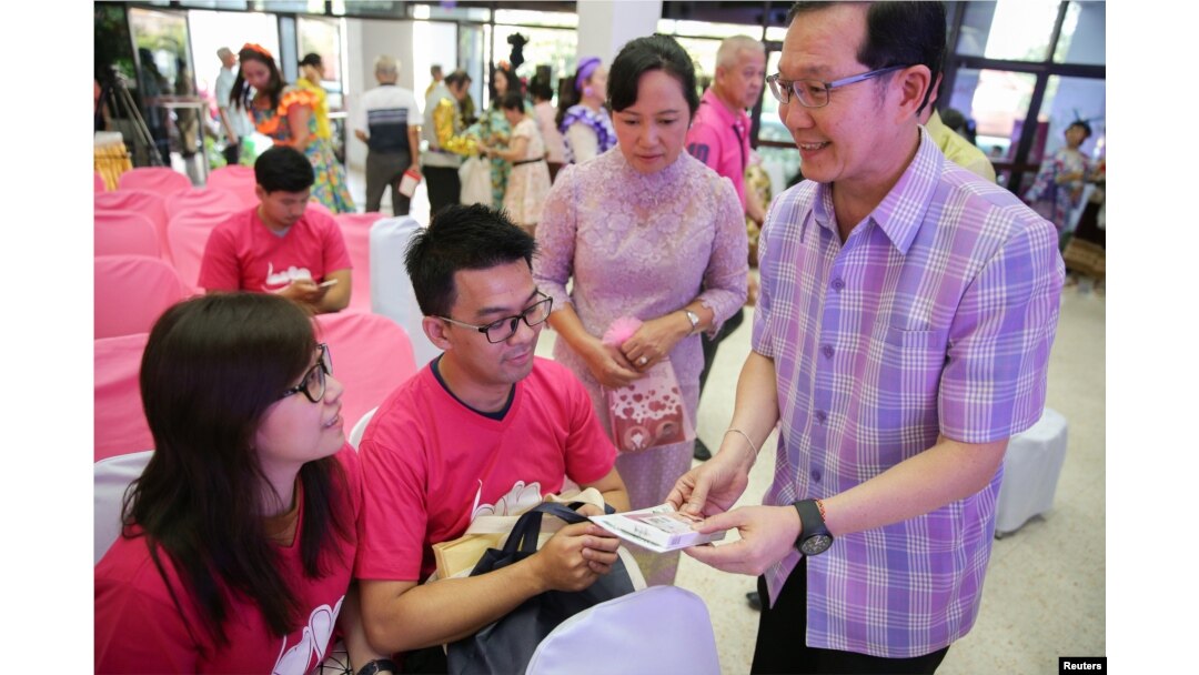 Petugas kesehatan membagikan vitamin pra-kehamilan kepada pasangan suami-istri dalam perayaan Hari Valentine, di Distrik Laksi, Bangkok, Thailand, 14 Februari 2018.