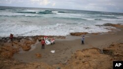 Des éléments de la Croix Rouge ramassent le corps d'un migrant mort par noyade lors d'une tentative de traversée pour l'Europe, à Khoms, Libye, 25 octobre 2015.