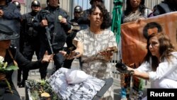 FILE - Activists take part in a protest against oil pollution in the Amazon jungle in front of the Petroperu (Petroleos del Peru) building in Lima, Peru, Aug. 22, 2016. 