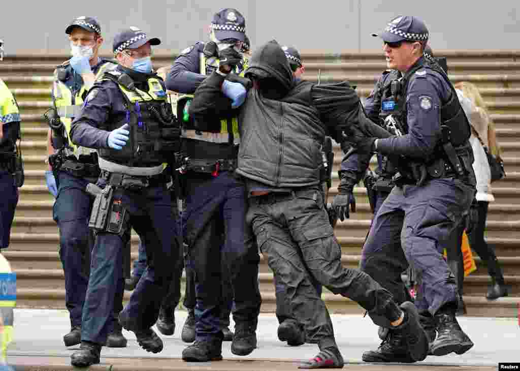 Police officers detain a protester opposing lockdown measures implemented to curb the spread of the coronavirus disease (COVID-19) outside Parliament House in Melbourne, Australia.