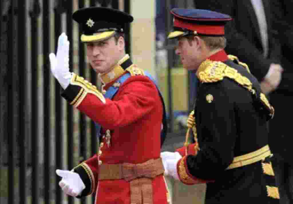 El príncipe Guillermo de Gran Bretaña saluda a las masas de gente que espera su llegada, junto a su hermano, el príncipe Harry en la puerta oeste de la Abadía de Westminster.