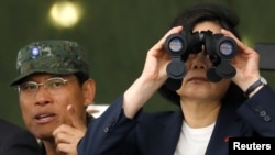 Taiwan's President Tsai Ing-wen looks through a pair of binoculars during anti-invasion drill, simulating the China's People's Liberation Army invading the island, in Taoyuan, Taiwan, Oct. 9, 2018.