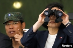 FILE - Taiwan's President Tsai Ing-wen looks through a pair of binoculars during anti-invasion drill, simulating the China's People's Liberation Army invading the island, in Taoyuan, Taiwan, Oct. 9, 2018.