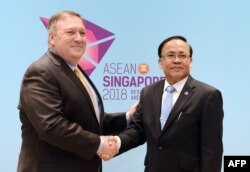 U.S. State Secretary Mike Pompeo, left, shakes hands with Myanmar's Union Minister for International Cooperation Kyaw Tin on the sidelines of the 51st Association of Southeast Asian Nations (ASEAN) Ministerial Meeting (AMM) in Singapore, Aug. 4, 2018.