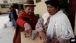 FILE - A woman is seen casting her ballot at a polling station during a referendum on allowing President Evo Morales to run for a fourth term in 2019, in El Alto, Bolivia, Feb. 21, 2016.