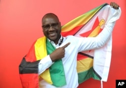 FILE - Pastor Evan Mawarire poses for a photo with the Zimbabwean flag wrapped around him, in Harare, Zimbabwe, May. 3, 2016. Mawarire rose to prominence last April when he posted a Facebook video of himself wrapped in a Zimbabwean flag, criticizing the state of affairs in the country.