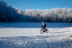Seorang pria mengendarai sepeda di taman kota di Stavropol dengan suhu udara sekitar minus 8 derajat Celcius. (Foto: REUTERS/Eduard Korniyenko)