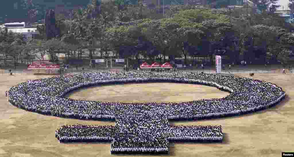 Participants form a female symbol as part of celebrations for International Women&#39;s Day in Manila, Philippines.