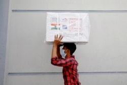 A worker carries a package of Oxford-Astrazeneca COVID-19 vaccines that arrived from India as a gift to Bangladesh, in Dhaka, Bangladesh January 21, 2021.