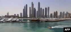 A picture taken on May 22, 2015 shows boats moored at the International Marine Club in front of skyscrapers in Dubai, United Arab Emirates. (Photo by KARIM SAHIB / AFP)