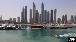 International Marine Club dengan latar belakang gedung pencakar langit di Dubai, Uni Emirat Arab, 22 Mei 2015. (AFP /KARIM SAHIB). Uni Emirat Arab  (UEA) akan mengganti pekan kerja resminya, ke Senin sampai Jumat, Selasa (7/12).