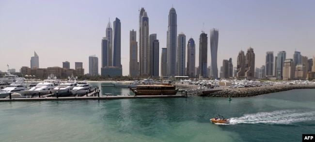 A picture taken on May 22, 2015 shows boats moored at the International Marine Club in front of skyscrapers in Dubai, United Arab Emirates. (Photo by KARIM SAHIB / AFP)