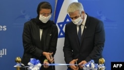 اسرائیلی وزیرِ خارجہ یائر لیپڈ فیتہ کاٹ کر سفارت خانے کا افتتاح کر رہے ہیں۔