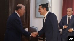 Greek Prime Minister Alexis Tsipras, center, welcomes U.S. Commerce Secretary Wilbur Ross, left, during their meeting in the northern port city of Thessaloniki, Greece, Sept. 7, 2018.