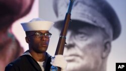 FILE - A Navy sailor and member of an honor guard stands in front of a photograph of Gen. Dwight D. Eisenhower during the groundbreaking at the site of the Dwight D. Eisenhower Memorial, in Washington, Nov. 2, 2017. 