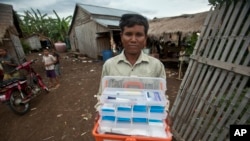 Medicinski radnik nosi pribor sa tradicionalnim lekovima za malariju u Kambadži. 