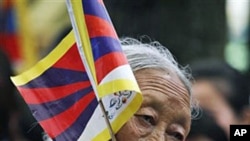 An exile Tibetan carries a Tibetan flag during a protest gathering in the Tsuglakhang temple in Dharmsala, India, Apr 24 2011