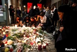 People cry as they light candles in tribute to the victims of the deadly shooting in Strasbourg, France, Dec. 13, 2018.