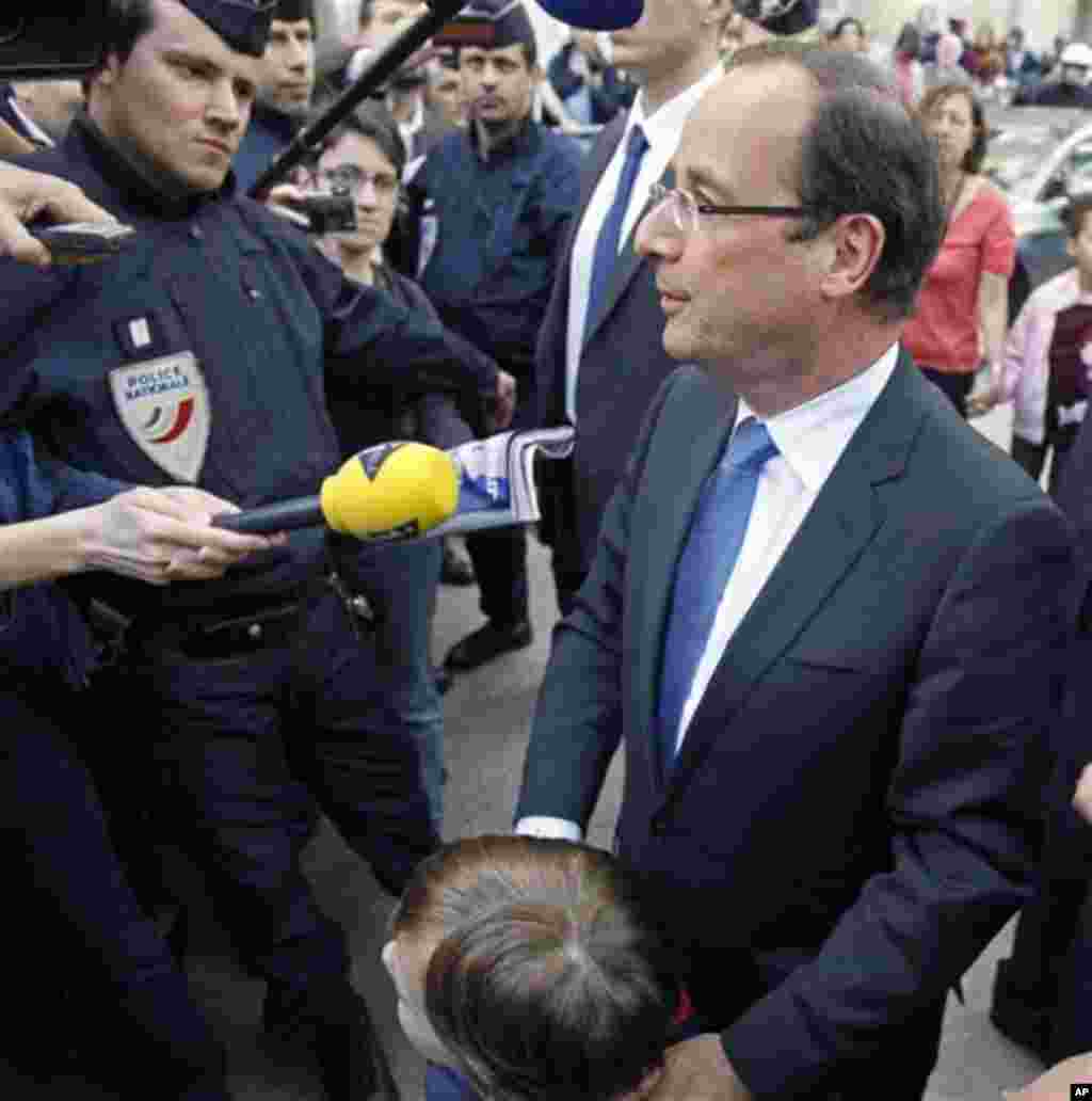 President-elect Francois Hollande addresses reporters as he leaves his campaign headquarters in Paris, Wednesday May 9, 2012. After winning the French Presidential Election, Hollande seems set to embark on a whir-wind introduction to international politi