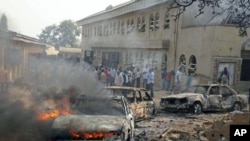 A car burns at the scene of a bomb explosion at St. Theresa Catholic Church at Madalla, Suleja, just outside Nigeria's capital Abuja, December 25, 2011.