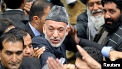 Afghan President Hamid Karzai leaves after the last day of the Loya Jirga, in Kabul, November 24, 2013.