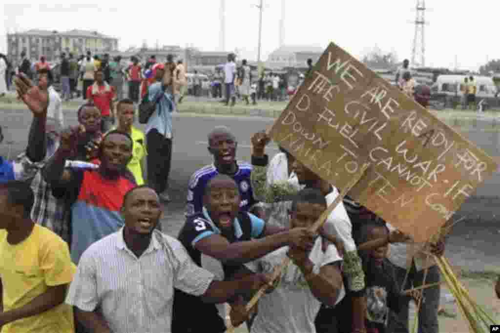 Angry youths protest with a placard 'We are ready for civil war if the fuel price cannot come down' on the third day of nation wide strike following the removal of a fuel subsidy by the government in Lagos, Nigeria, Wednesday, Jan. 11, 2012. Nigeria;s g