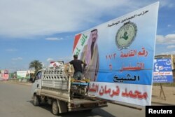 A vehicle carries a campaign poster of a candidate ahead of parliamentary elections, in Mosul, Iraq, April 30, 2018.