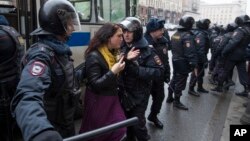 Police officers try to detain a woman in Moscow, April 2, 2017. 