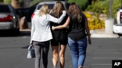 Kris Delarosby, right, and Colleen Anderson, left, hold Charleen Jochim as they walk toward a hospital in search of information about a missing friend, Steven Berger of Minnesota, Oct. 3, 2017, in Las Vegas. The parents of Berger, who had been missing after the mass shooting in Las Vegas, said they had been notified Tuesday afternoon that he was killed in the attack.