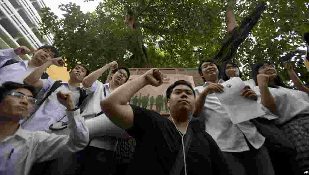 Para anggota Pusat Mahasiswa/i Thailand untuk Demokrasi mengangkat tinju ke udara dalam sebuah protes melawan kudeta militer di Thammasat University di Bangkok (29/5).&nbsp;(AP/Sakchai Lalit)