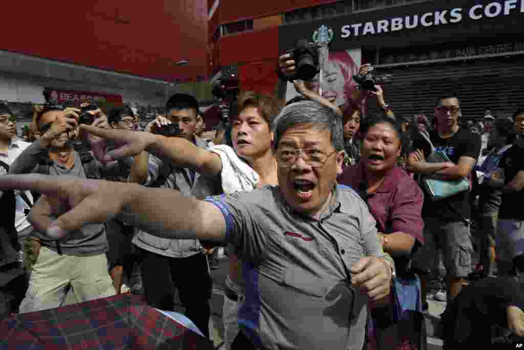 Local residents shout to a pro-democracy protester at a main street at Mong kok district in Hong Kong Friday, Oct. 17, 2014.