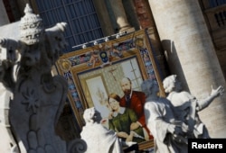 A tapestry showing Louis and Zelie Martin, parents of St. Therese of Lisieux, hangs from a balcony as Pope Francis leads the mass for their canonization in Saint Peter's Square at the Vatican, Oct. 18, 2015.