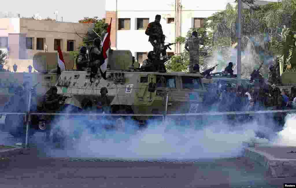 Security forces watch over supporters of former Egyptian President Mohamed Morsi during clashes outside the Republican Guard building in Cairo, July 5, 2013.