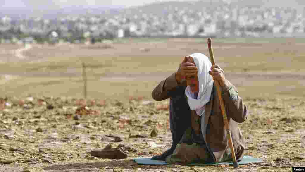 Người Kurd tị nạn phản ứng khi nhìn thấy khói bốc lên từ thị trấn Kobani ở Syria sau các vụ không kích, ngày 26/10/2014. 