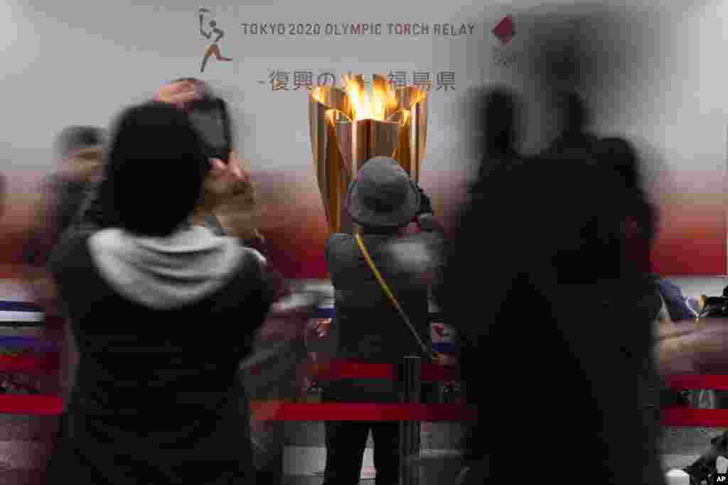 مردم در حال گرفتن عکس از مشعل المپیک در مراسمی که در شهر فوکوشیما ژاپن برگزار شده است. امروز رسما اعلام شد المپیک با یکسال تاخیر برگزار می&zwnj;شود.&nbsp;