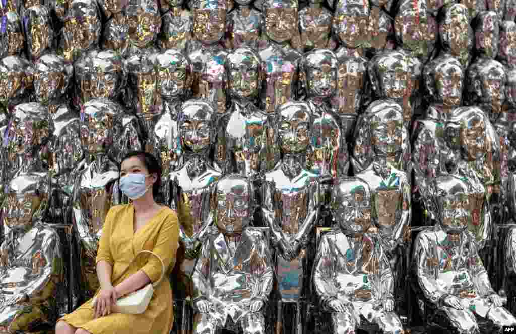 A woman wearing a face mask poses for a picture at a shopping centre in Beijing, China.