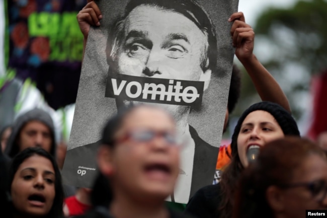 Un manifestante muestra una foto del candidato presidencial brasileño Jair Bolsonaro, durante una protesta conra él en Sao Paulo, Oct. 6, 2018.