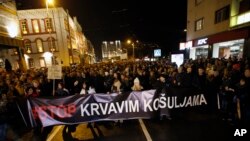 People hold a banner that reads: ''Stop to bloody shirts'' during a protest in Belgrade, Serbia, Dec. 8, 2018. Thousands of people marched in Serbia against the autocratic rule of President Aleksandar Vucic and his government. 