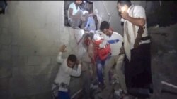 An image provided by Al-Masirah TV on Jan. 21, 2022, shows Yemenis rescuing a man from a site following Saudi-led airstrikes on Yemen's rebel-held port city of Hodeidah.