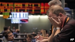 Trader Andrew Stavros reacts after the close of trading in the NASDAQ, 100 Index pit, on the floor of The CME Group Monday, Aug. 8, 2011, in Chicago.