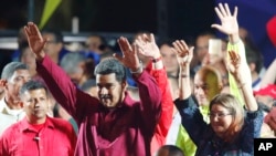 Venezuela's President Nicolas Maduro and his wife Cilia Flores wave to supporters at the presidential palace in Caracas, Venezuela, Sunday, May 20, 2018. (AP Photo/Ariana Cubillos)