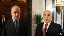 Iraq's Prime Minister Haider al-Abadi, right, stands with Iraqi Foreign Minister Ibrahim al-Jaafari at the Prime Minister's Office in Baghdad, Iraq, Jan. 21, 2015. 