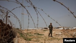 Anggota pasukan keamanan Palestina yang loyal pada Hamas menjaga perbatasan antara Mesir dan Jalur Gaza (4/3). (Reuters/Ibraheem Abu Mustafa)
