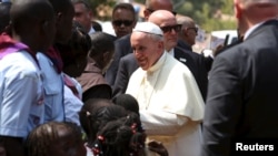 Pope Francis greets internally displaced people sheltering on the grounds of the Saint Sauveur church, during his visit in the capital Bangui, Central African Republic, Nov. 29, 2015.