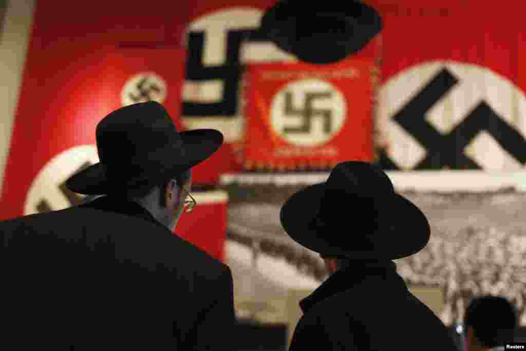 Ultra-Orthodox Jewish visitors look at a display of Nazi flags at Yad Vashem’s Holocaust History Museum in Jerusalem ahead of International Holocaust Remembrance Day which will be marked on January 27.